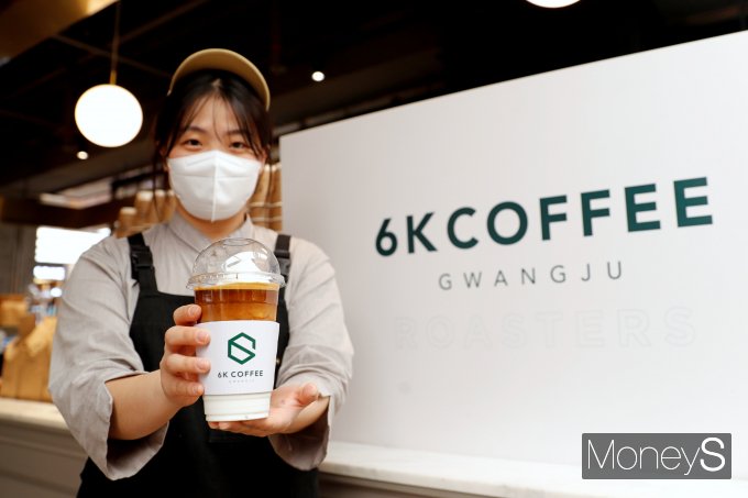  광주신세계 본관 지하 1층 지역 토종 브랜드 '육각커피'매장 직원이 시그니처 메뉴인 코코넛 커피를 선보이고 있다/사진=광주신세계 제공.
