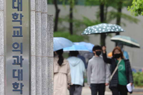 집단 유급 한계선에 임박해 수업을 재개하기로 했던 의과대학 일부가 학생들의 출석률 저조로 다시 수업 일정을 미뤘다. 지난 15일 오후 서울 시내 의대 앞으로 시민들이 지나가고 있다. /사진=뉴시스