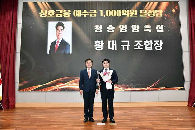 황대규 청송영양축협 조합장(오른쪽)이 농협이 주관하는 상호금융예수금 1000억 원 달성탑을 들어보이고 있다./사진제공=청송영양축산업협동조합