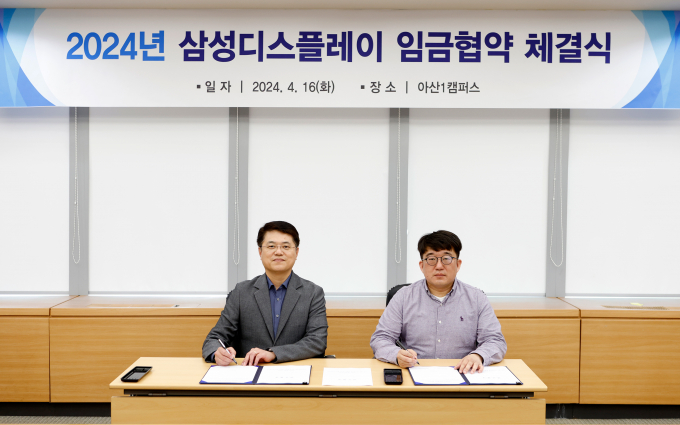 16일 삼성디스플레이 아산1캠퍼스에서 열린 '2024년 임금협약 체결식'에서 한준호 피플팀장(상무, 왼쪽)과 유하람 열린노동조합지부장이 협약서에 서명하고 있다. / 사진=삼성디스플레이 
