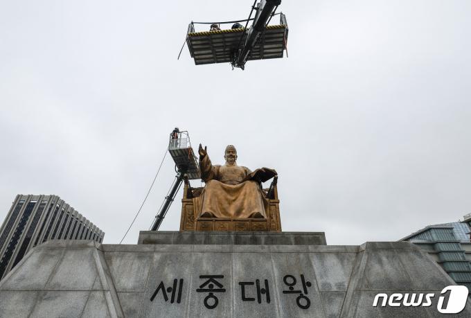서울시 관계자들이 16일 오전 서울 세종대로 광화문 광장에서 세종대왕 동상을 세척하고 있다. 최근 황사와 미세먼지로 묵은 때가 동상을 두껍게 덮고 있어 세척 작업은 총 4단계(먼지 제거·세척·이물질 제거·코팅)로 이뤄진다. (공동취재) 2024.4.16/뉴스1 ⓒ News1 김민지 기자