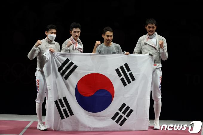 펜싱 오상욱, 구본길, 김정환, 김준호가 28일 일본 지바 마쿠하리 메세 B홀에서 열린 '2020 도쿄올림픽' 펜싱 남자 사브르 단체 결승전 이탈리아와의 경기에서 승리한 뒤 태극기를 들고 있다. 2021.7.28/뉴스1 ⓒ News1 송원영 기자