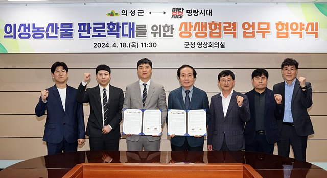 김주수 의성군수(왼쪽에서 네번째)가 18일 의성군청 영상회의실에서 명랑시대와 상생협력 업무 협약식을 가진 뒤 협약서를 들어보이고 있다./사진제공=경북 의성군