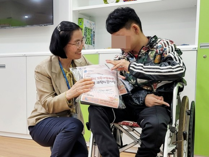  수원시가족여성회관이 오는 9월까지 '편의복 제작·지원 사업'을 추진하고 있는 가운데 한 장애인이 회관이 리폼·수선한 편의복을 전달받고 있다. / 사진제공=수원도시공사 