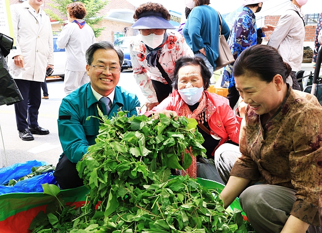 오도창 영양군수(왼쪽)이 지난해 열린 제18회 산나물축제장에서 산나물을 들어보이고 있다./사진제공=경북 영양군