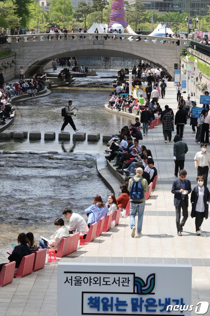 서울야외도서관 운영 첫 날인 18일 서울 종로구 청계천 마련된 '책 읽는 맑은냇가'를 찾은 시민들이 독서와 산책을 즐기고 있다. 2024.4.18/뉴스1 ⓒ News1 장수영 기자