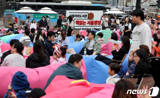 서울야외도서관 운영 첫 주말을 맞은 21일 오후 서울 중구 서울광장에 마련된 '책읽는 서울광장'을 찾은 시민들이 독서와 산책을 즐기고 있다. 2024.4.21/뉴스1 ⓒ News1 장수영 기자