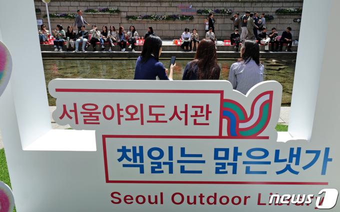 서울야외도서관 운영 첫 날인 18일 서울 종로구 청계천 마련된 '책 읽는 맑은냇가'를 찾은 시민들이 독서와 산책을 즐기고 있다. 2024.4.18/뉴스1 ⓒ News1 장수영 기자