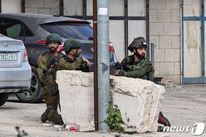 4일 (현지시간) 팔레스타인 무장 정파 하마스의 전쟁 중인 이스라엘 군이 요르단 강 서안 지구 인근 툴카름에 있는 누르 샴스 난민 캠프에서 공격 중 피신을 하고 있다. (사진은 기사 내용과 무관함) / 뉴스1 ⓒ News1 2024.1.5 ⓒ AFP=뉴스1 ⓒ News1 우동명 기자