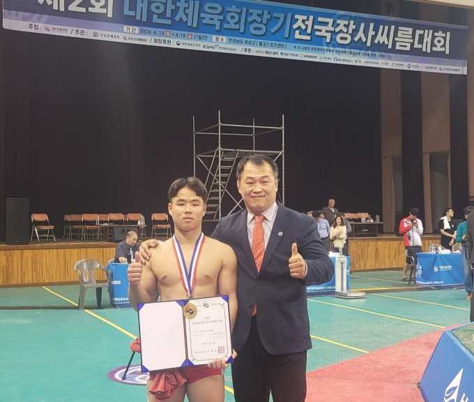 부산반여고 정상원 선수(왼쪽)가 전국장사씨름대회 개인전 우승을 차지한 뒤 박상규 감독과 포즈를 취하고 있다. /사진=부산씨름협회