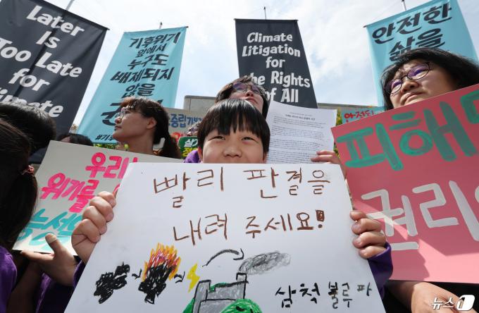 23일 서울 종로구 헌법재판소 앞에서 열린 기후 헌법소원 공개변론 기자회견에 참석한 어린이가 빠른 판결을 촉구하는 손팻말을 들고 있다. 이날 헌법재판소는 이른바 ‘기후 소송’에 대한 첫 공개 변론을 진행한다. 2024.4.23/뉴스1 ⓒ News1 박지혜 기자