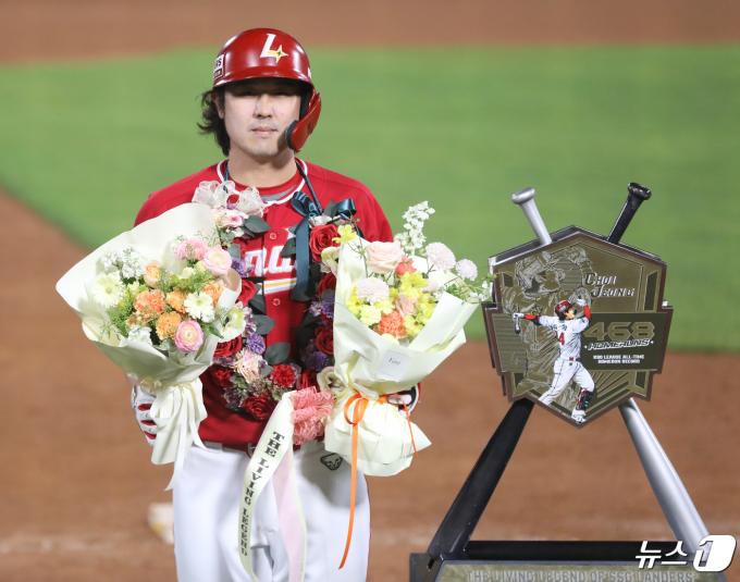 24일 오후 부산 사직야구장에서 열린 '2024 신한 SOL 뱅크 KBO리그' 롯데 자이언츠와 SSG 랜더스의 경기, 5회초 2사 주자 없는 상황 SSG 최정이 468호 홈런을 치고 KBO리그 통산 최다 홈런 신기록을 달성한 뒤 꽃다발을 들고 기념사진을 찍고 있다. 2024.4.24/뉴스1 ⓒ News1 윤일지 기자
