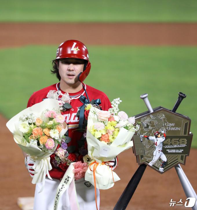 24일 오후 부산 사직야구장에서 열린 '2024 신한 SOL 뱅크 KBO리그' 롯데 자이언츠와 SSG 랜더스의 경기, 5회초 2사 주자 없는 상황 SSG 최정이 468호 홈런을 치고 KBO리그 통산 최다 홈런 신기록을 달성한 뒤 꽃다발을 들고 기념사진을 찍고 있다. 2024.4.24/뉴스1 ⓒ News1 윤일지 기자