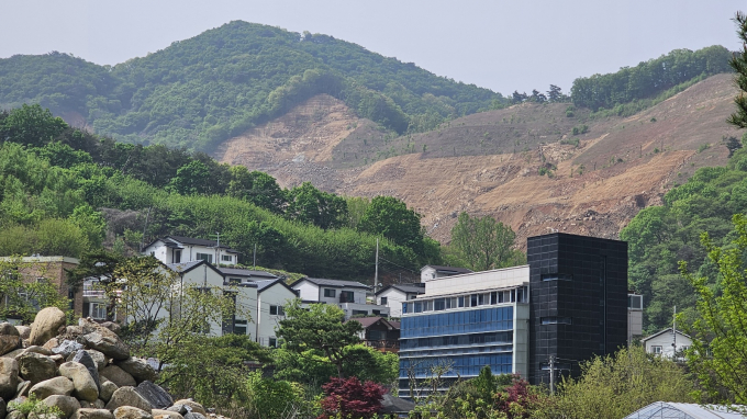 <머니S>가 매립 현장을 둘러보니 채석장은 이미 반입된 다량의 토사가 체계적인 산지조성 과정도 없이 제멋대로 쌓여서 여름철 큰 비가 오면 쓸려 내려갈 것처럼 아슬아슬해 보였다. 실제로 지난해 여름 장마철에는 쌓인 토사가 일부 무너져 내리기도 했다. B업체는 이를 임시로 복구해 놓은 상태여서 인근 주민들의 걱정은 커져만 가고 있다. 사진은 마을에서 바라본 채석장 모습(2024년 26일 촬영). / 사진=이건구 기자