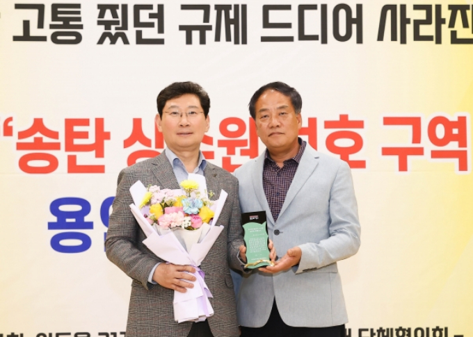 이상일 용인특례시장(왼쪽)이 24일 처인구 이통장연합회가 남사읍 주민자치센터에서 개최된 송탄 상수원 보호구역 해제 협약 기념 연합회의에서 감사패를 받고 있다.  / 사진제공=용인특례시