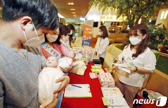 27일 광주 북구 빛고을여성병원에서 열린 저출산 대응 민관 릴레이 캠페인에서 북구청 저출산아동정책팀 직원들과 인구보건복지협회원들이 임산부와 예비아빠 등에게 신생아 속싸개 싸는 법 등 출산장려 홍보활동을 펼치고 있다. (광주북구 제공)2020.5.27/뉴스1 ⓒ News1 황희규 기자