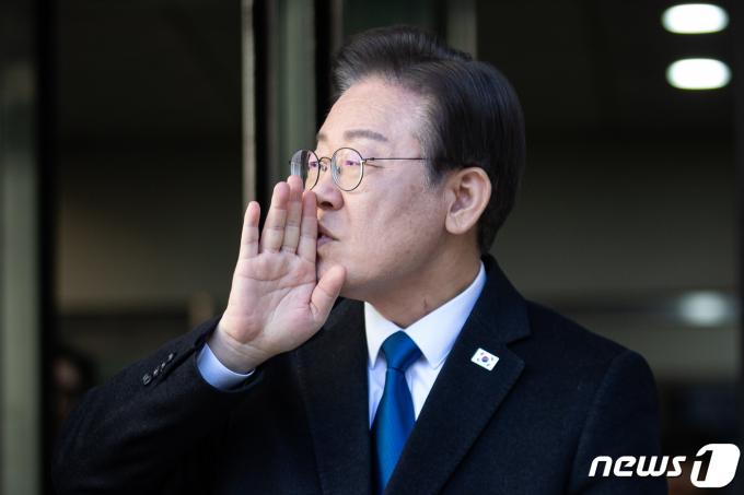 이재명 더불어민주당 대표가 3월8일 서울 서초구 중앙지방법원에서 열린 '허위사실 공표' 공직선거법위반 공판에 출석하며 입장을 밝히기 전 지지자들을 향해 조용히 해달라고 손짓하고 있다. 2024.3.8/뉴스1 ⓒ News1 유승관 기자