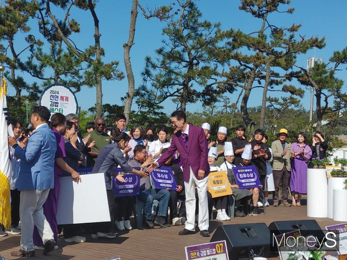 박우량 군수(사진 가운데 퍼플색 정장)가 지난 27일 신안세계김밥페스타 행사에서 수상한 팀을 격려하고 있다./홍기철기자