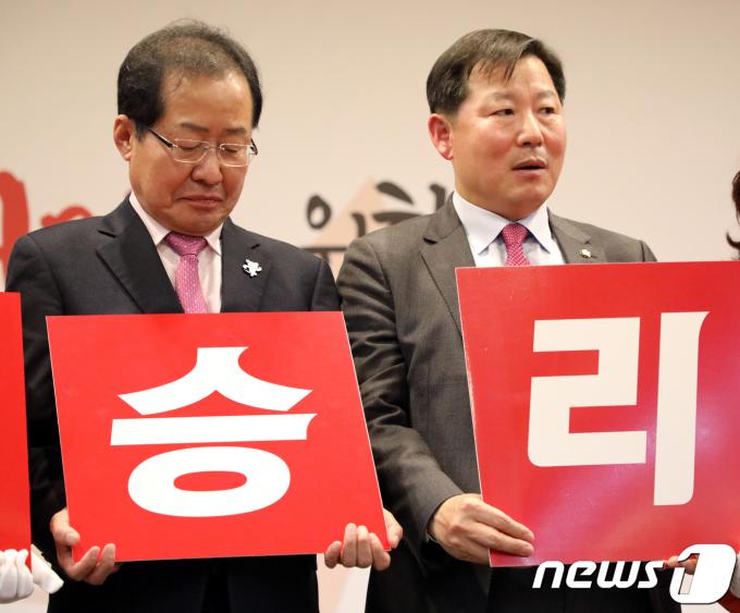 2018년 1월 16일 당시 홍준표 자유한국당 대표와 이철규 강원도당 위원장이 강원 춘천시에서 열린 자유한국당 강원도당 신년인사회에 참석해 6.13지방선거 필승결의문낭독에서 '승리' 피켓을 들고있다.2018.1.16/뉴스1 ⓒ News1 DB
