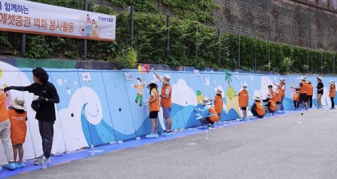 사진은 지난해 5월 부산 괘법초등학교에서 진행된 벽화 그리기 봉사활동. /사진=미래에셋증권