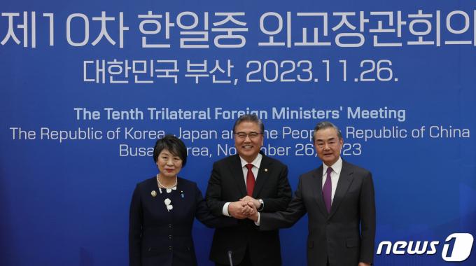 박진(가운데) 외교부 장관, 가미카와 요코(왼쪽) 일본 외무상, 왕이 중국 외교부장이 26일 오후 부산 해운대구 누리마루 APEC하우스에서 열린 한일중 외교장관 회의에서 손을 맞잡고 기념촬영을 하고 있다. 2023.11.26/뉴스1 ⓒ News1 김명섭 기자