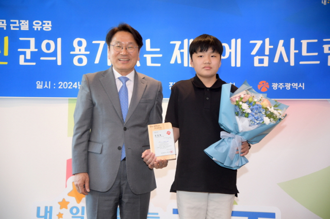 강기정 광주광역시장이 13일 오후 시청에서 5‧18 왜곡‧폄훼 게임을 언론에 제보한 이호진 군에게 표창패를 수여한 후 기념촬영을 하고 있다./사진=광주시