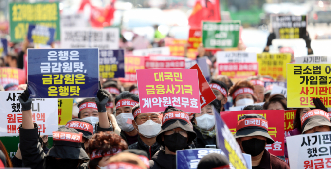  홍콩H지수(항셍중국기업지수) 기초 주가연계증권(ELS) 피해자 모임 회원들이 15일 오후 서울 중구 NH농협은행 앞에서 열린 '대국민 금융 사기 규탄 집회'에서 투자 원금 전액 배상 등 계약 무효를 촉구하는 피켓을 들고 있다./사진=뉴시스