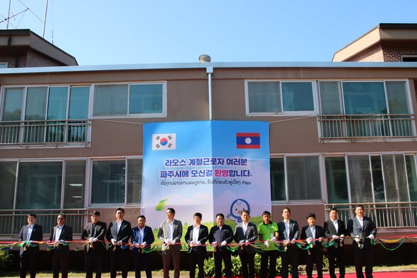   김진기 파주시 부시장(오른쪽 여덟번째)이 13일 문산읍 선유리 외국인 계절근로자 숙소에서 열린 공공형 농촌인력중개센터 개소식에서 이갑영 북파주농업협동조합장 등 내빈들과 함께 테이프 커팅을 하고 있다. / 사진제공=파주시