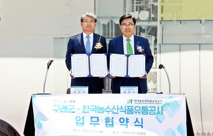  김춘진 한국농수산식품유통공사 사장(오른쪽)과 김순호 구례군수가 16일 구례군청에서 K-푸드 수출 확대와 저탄소 식생활 확산을 위한 업무협약을 체결한 뒤 기념촬영을 하고 있다./사진제공=aT