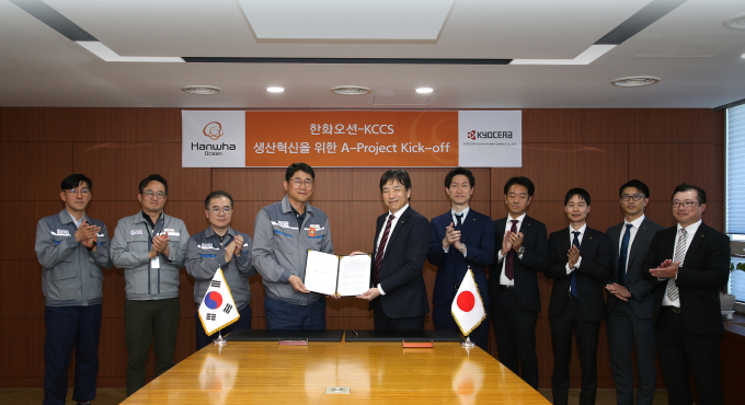 한화오션 조선소장 이길섭 부사장(왼쪽에서 네번째)이 교세라社의 마츠나가 카즈히로 사업부장(왼쪽에서 다섯번째)과 계약서에 서명하고 기념 촬영하고 있다. /사진=한화오션