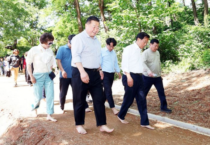 김경일 시장과 주민 등 관계자들이 새암공원 맨발걷기 길을 걷고 있다. / 사진제공=파주시 