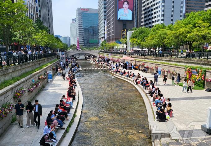 서울 낮 최고 기온이 25도까지 오르며 초여름 날씨를 보인 17일 서울 청계천에서 열린 서울야외도서관-책 읽는 맑은 냇가에서 시민들이 의자에 앉아 책을 보며 휴식을 취하고 있다. 2024.5.17/뉴스1
