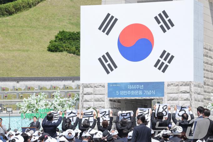 제44주년 5.18민주화운동 기념식이 열린 18일 오전 윤석열 대통령의 기념사 도중 광주시의회 5.18특위 위원 8명이 '5.18 헌번전문수록'이 적힌 소형 현수막을 들고 기습 퍼포먼스를 벌이고 있다. 2024.5.18/뉴스1 ⓒ News1 김태성 기자