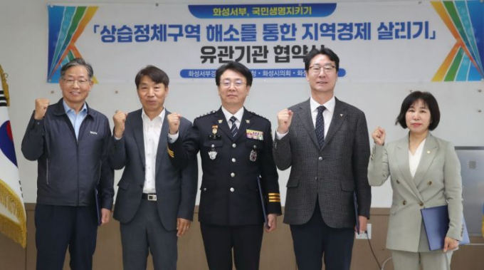  이택원 화성상공회의소 부회장(왼쪽부터)과 이홍근 경기도의원, 김원식 화성서부경찰서장, 정명근 화성시장, 김경희 화성시의회 의장이 21일 화성서부경찰서에서 열린 '상습정체구역 해소를 통한 지역경제 살리기' 업무협약식에서 교통사고 감소를 위한 협력을 다짐하고 있다. / 사진제공=화성시