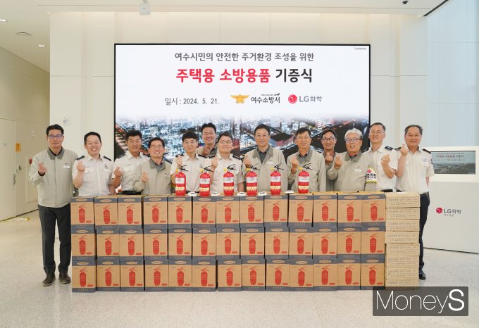 이현규 LG화학 여수공장 주재임원을 비롯한 LG화학 여수공장 임직원들이 21일 박원국 여수소방서장을 비롯한 소방관들에게 보훈가족이 사용할 주택용 소방용품을 전달하고 기념사진을 찍고 있다/사진=LG화학 여수공장 제공.