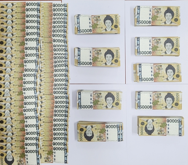 경찰이 A씨 일당으로부터 압수한 위조된 5만 원 지폐들, A씨 등 18명은 위조통화취득 등의 혐의로 경찰에 입건됐다./사진제공=경북 구미경찰서
