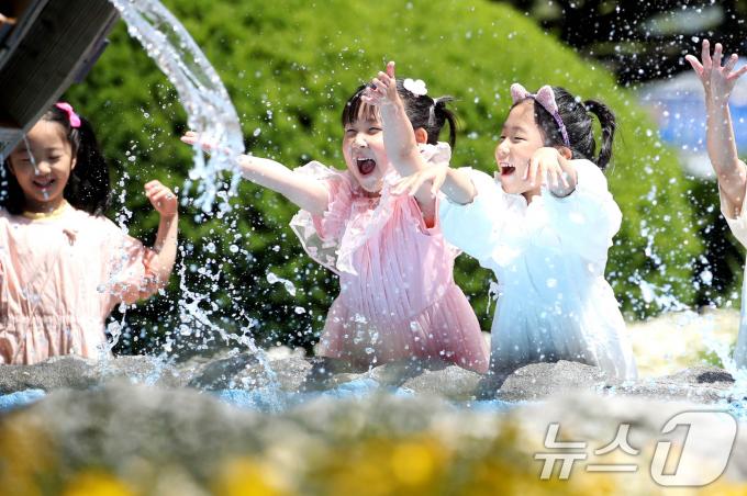 초여름 날씨를 보인 21일 광주 북구청 광장으로 야외활동 나온 북구청직장어린이집 아이들이 물레방아에서 물장구를 치며 즐거워 하고 있다. (광주 북구 제공) 2024.5.21/뉴스 ⓒ News1 이승현 기자