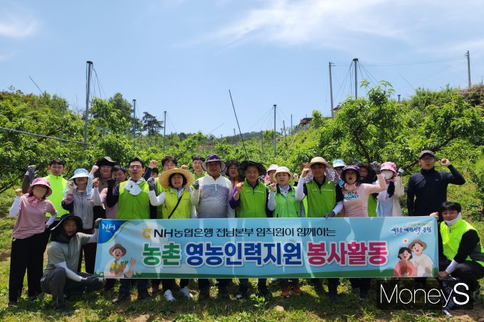  정재헌 농협은행 전남본부장, 김정수 동복농협 조합장을 비롯한 임직원 20여명이 지난 23일 화순군 백아면 소재 복숭아 농장에서 농촌일손돕기를 실시한 후 기념사진을 찍고 있다/사진=농협전남본부 제공.