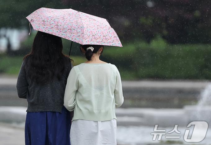 [사진] '양산 하나에 의지하며'
