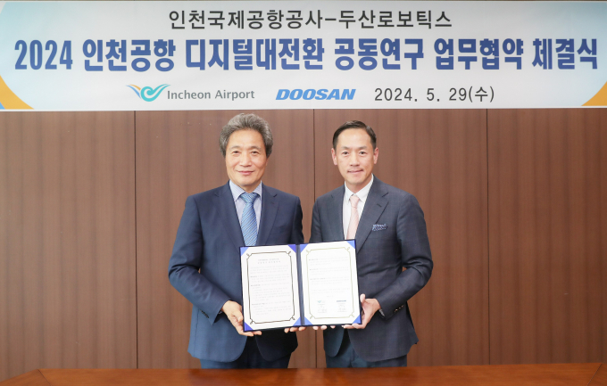 인천국제공항 디지털 전환 추진 협업 체계 구축’을 위한 업무협약식이 끝나고 두산로보틱스 박인원 대표(오른쪽)와 인천국제공항공사 이학재 사장이 기념사진을 촬영하고 있다./사진제공=두산로보틱스
