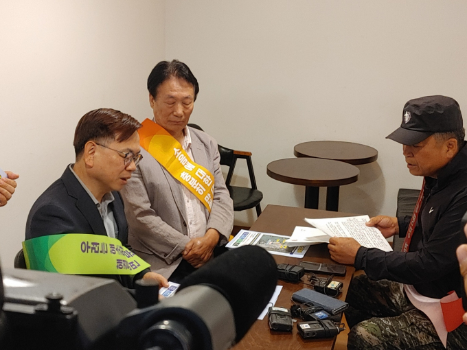 30일 무안 망운면의 한 커피숍에서 고광완 광주광역시 행정부시장(왼쪽)과 송남수 망운명 번영회장(오른쪽)이 민간군공항 무안이전 문제, 강기정 시장의 약속의 편지1에 대해 불편한 설전을 벌이고 있다./홍기철기자