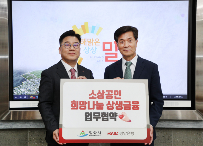 29일 밀양시청 시장실에서 업무협약을 체결한 후 안병구 밀양시장(오른쪽)과 허종구 경남은행 본부장이 기념촬영을 하고 있다./사진=밀양시
