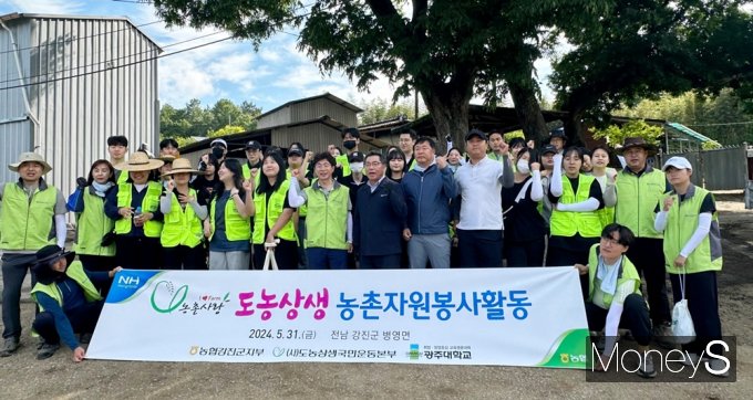농협전남본부 임직원과 광주대학교 농촌봉사단이 31일 강진 병영의 한 마늘 재배 농가에서 일손돕기를 마친 후 기념촬영을 하고 있다./사진=광주대학교 제공.