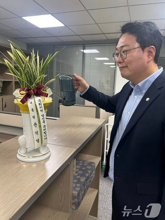 천하람 개혁신당 원내대표가 윤석열 대통령이 보낸 축하난에 물을 주고 있다. (SNS 갈무리) ⓒ 뉴스1