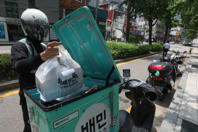  배달앱 배달의민족을 운영하는 우아한 형제들이 음식점주들에게 배달뿐 아니라 포장 주문을 받는 경우에도 중개 이용료를 받기로 했다. 사진은 지난 2021년 5월 서울의 한 대학가에 배달 라이더들이 이동하는 모습. /사진=뉴스1