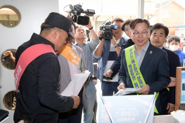 고광완 광주시 행정부시장이 지난달 30일 무안군 망운면 상가일대에서 시 공직자들과 함께 주민들에게 홍보전단지를 배부하며 민간·군공항 통합이전 홍보 활동을 하고 있다./사진=광주시 