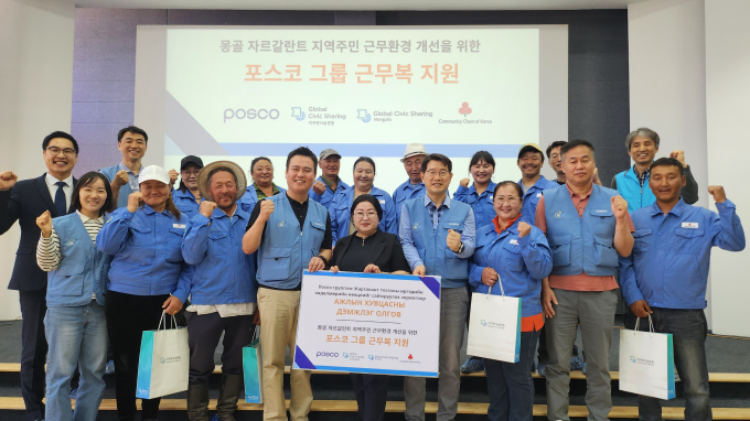포스코 노사 관계자들이 몽골 자르갈란트 지역 목축농가 주민들에게 포스코 구형 근무복을 전달하고 기념사진을 찍고 있다. /사진=포스코