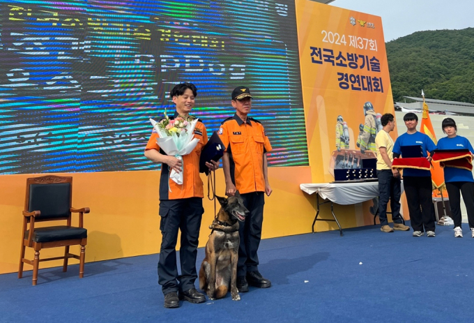 경기도 인명구조견 ‘태공’이 전국 소방기술경연대회 119구조견 부문에서 1위를 차지한 뒤 조련사인 오문경 소방위(오른쪽)와 기념 촬영을 하고 있다. /사진제공=경기도