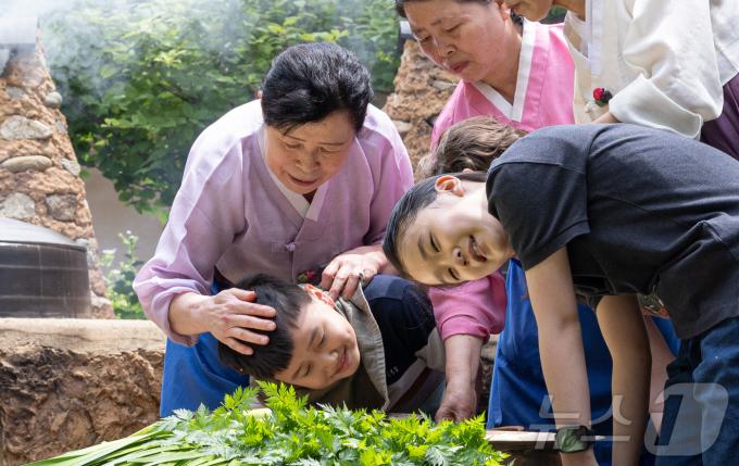단오(음력 5월5일)를 하루 앞둔 9일 경기도 용인시 기흥구 한국민속촌에서 어린이들이 창포물에 머리 감기 체험을 하고 있다. 2024.6.9/뉴스1 ⓒ News1 이재명 기자