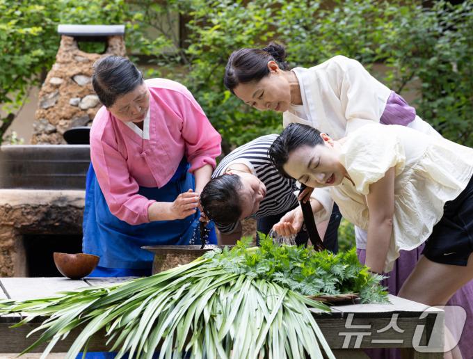 단오(음력 5월5일)를 하루 앞둔 9일 경기도 용인시 기흥구 한국민속촌에서 외국인 관광객들이 창포물에 머리 감기 체험을 하고 있다. 2024.6.9/뉴스1 ⓒ News1 이재명 기자
